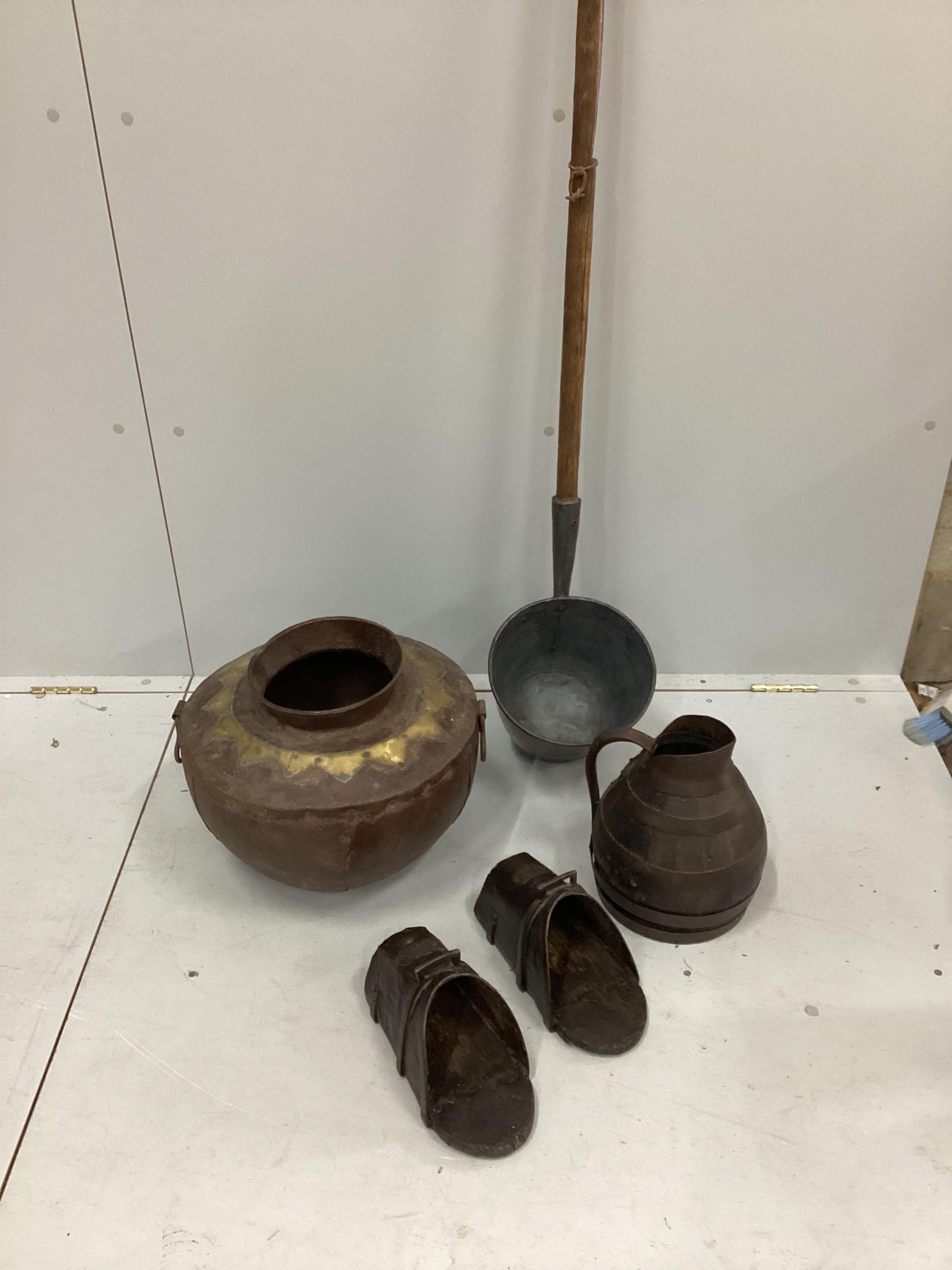 A Victorian ash handled dairy ladle, a coopered oak jug, a pair of Spanish iron mounted stirrups and an Eastern brass mounted container.